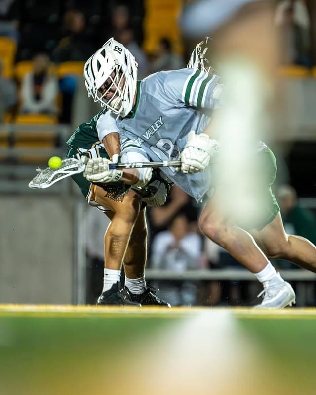 Jake Lundin taking the ball during a Utah Valley lacrosse faceoff.
